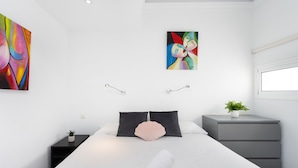 A modern bedroom with a large bed, a bedside table with a plant, and a nightstand. - Fabuloso apartamento con magnificas vistas al mar (Callao Salvaje)