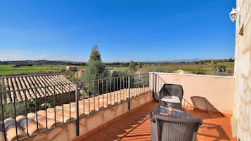 Relax on the furnished terrace with a scenic view of the surrounding hills and lush vegetation.