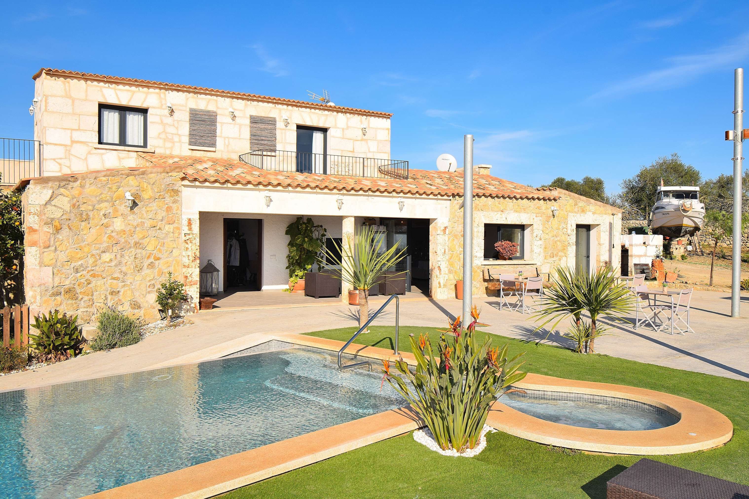 A stone building with a swimming pool, outdoor seating, and a satellite dish.