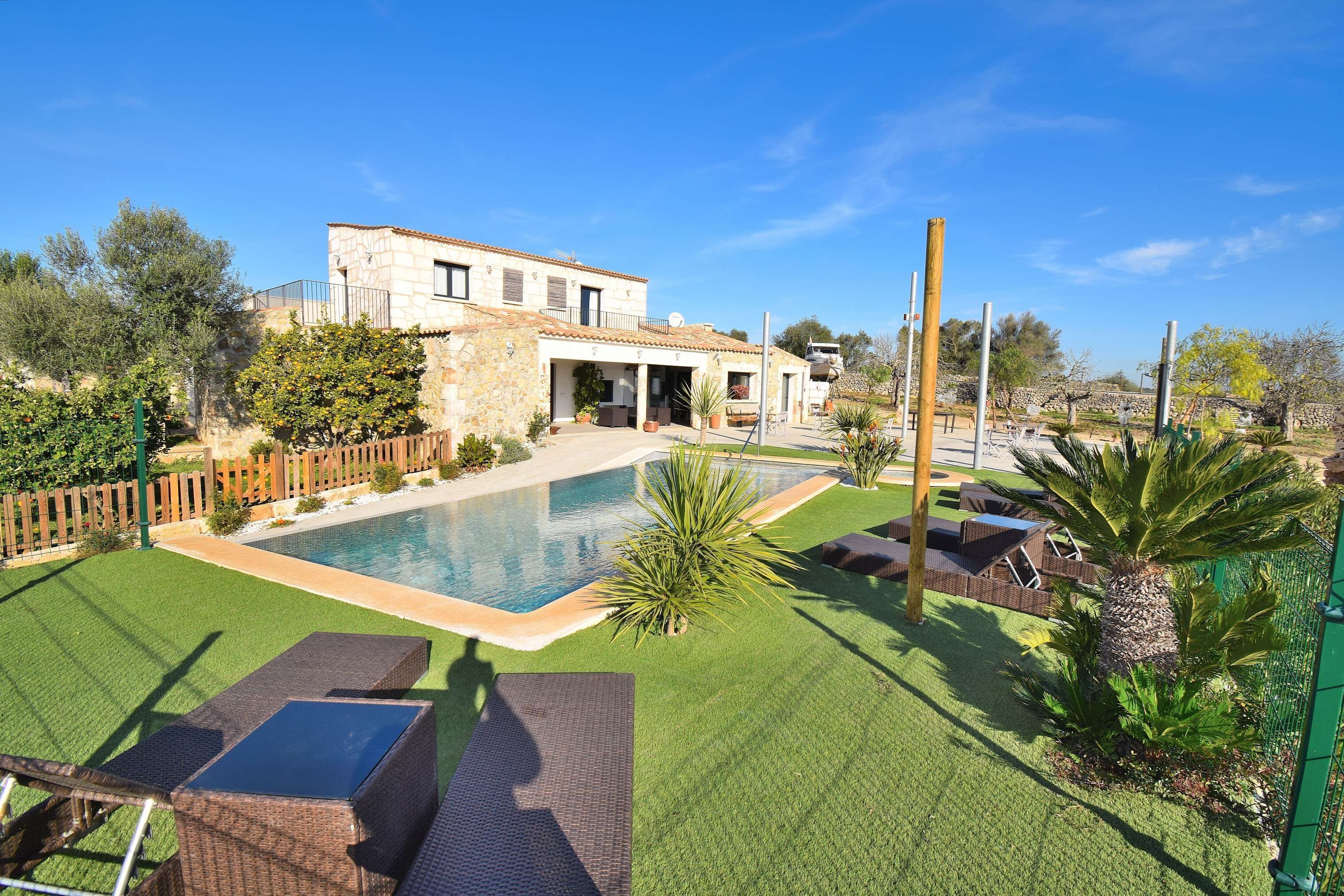 Una piscina al aire libre, sombrillas, sillones reclinables de piscina