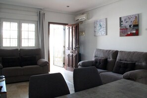 A living room with two sofas, a coffee table, and a door leading to an outdoor area.