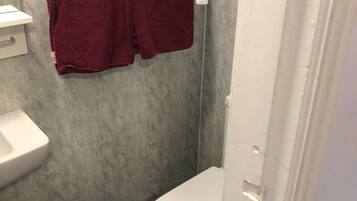 Un baño pequeño con un lavabo blanco, un inodoro y una cortina de ducha.