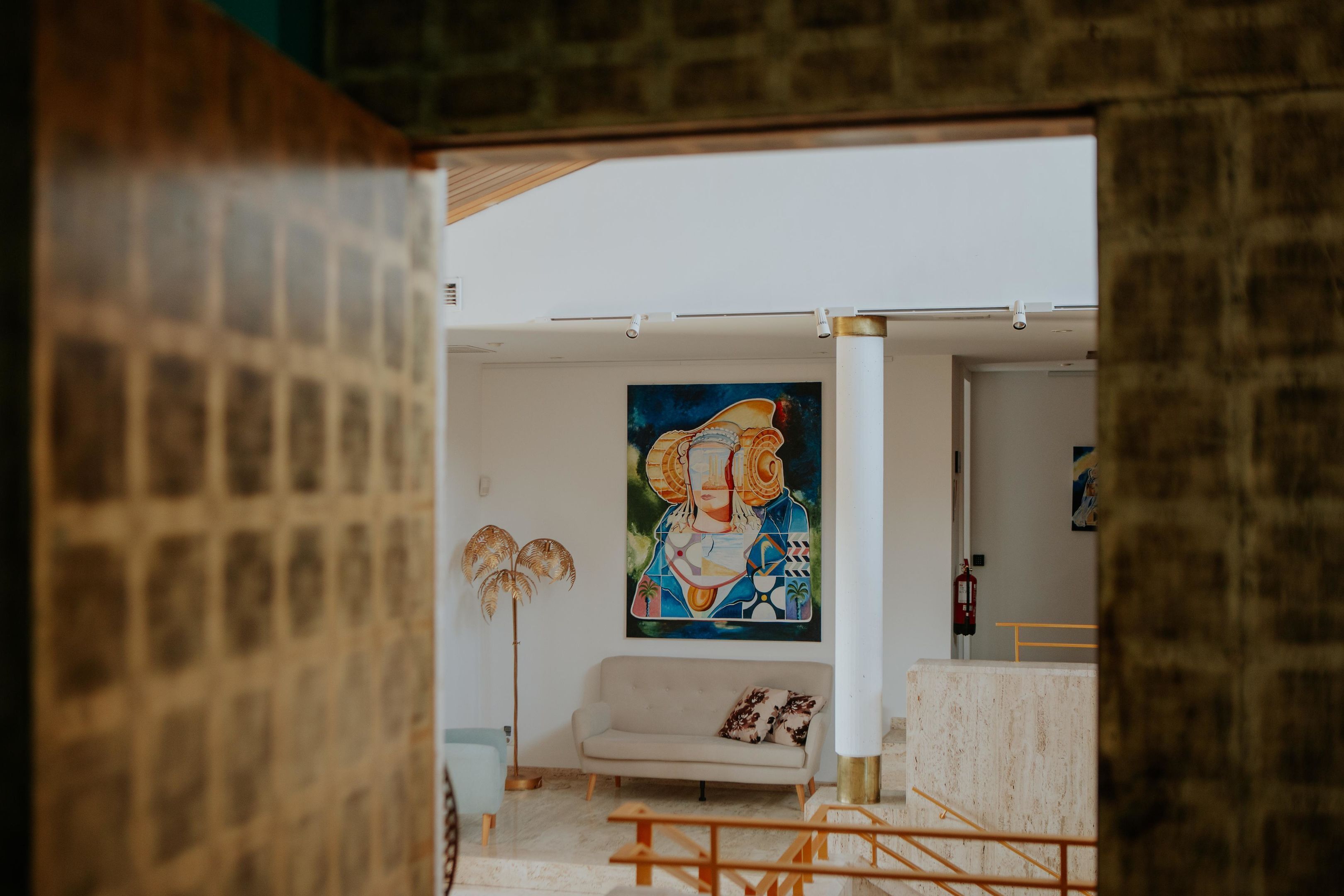 A modern living room with a large abstract painting, a sofa, and a floor lamp.