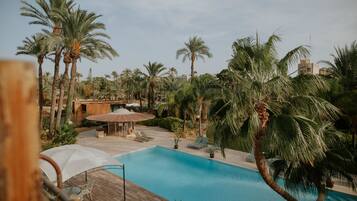 Een buitenzwembad, parasols bij het zwembad en ligstoelen