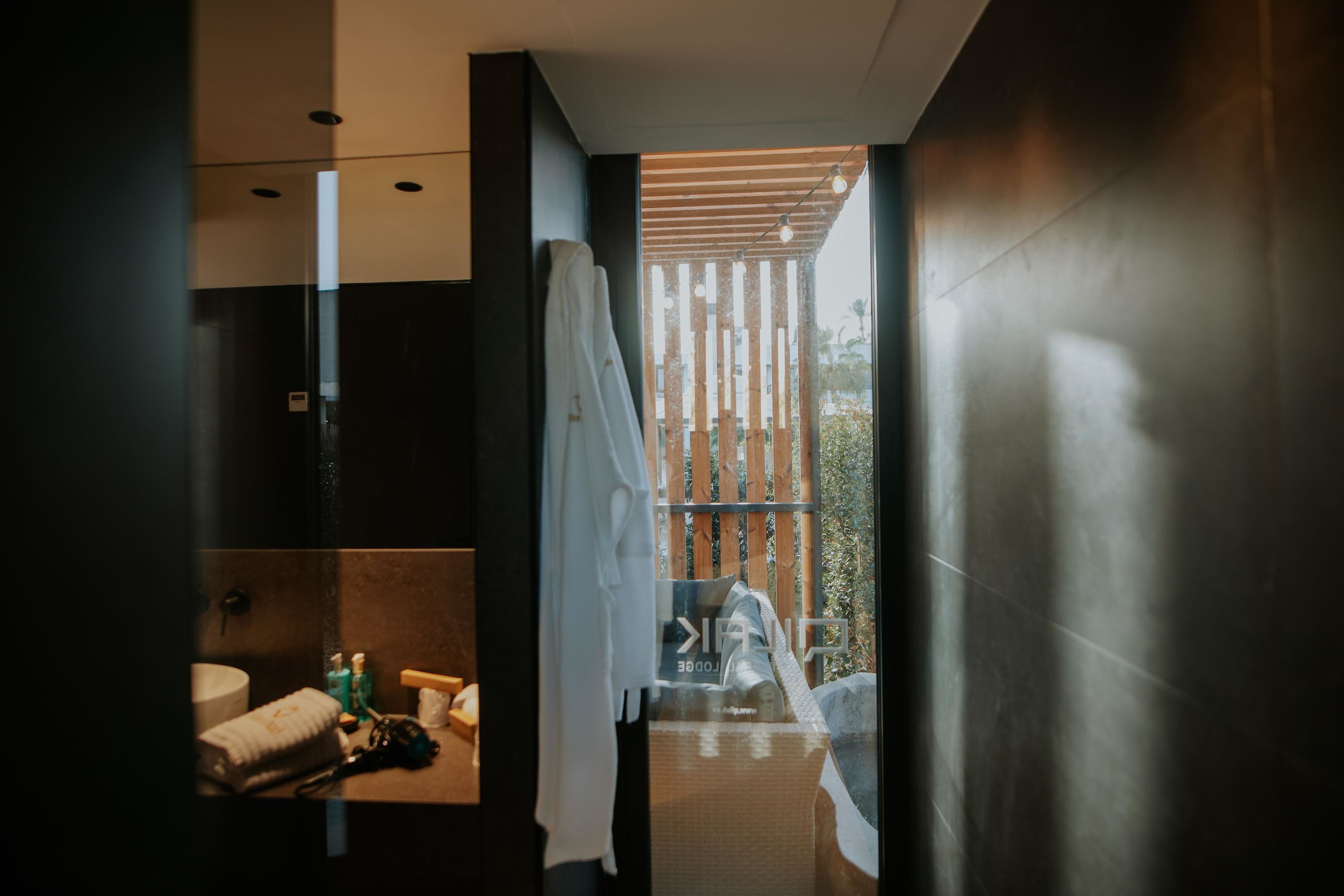 Ein modernes Badezimmer mit einem großen Spiegel, einem Handtuchhalter und einem Waschbecken.