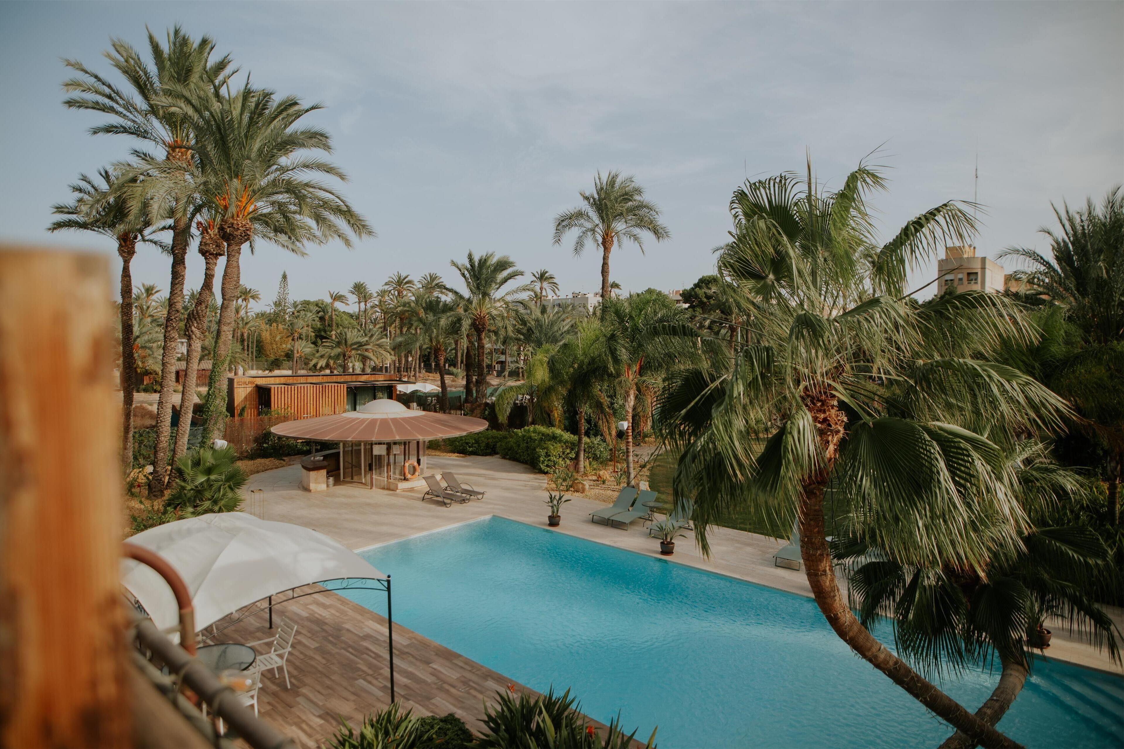 Een buitenzwembad, parasols voor strand/zwembad