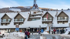 A lodge with multiple chalet-style buildings, a ski lift, and a church spire. - PRIME SKI-IN/OUT LOCATION - Park City Mountain Resort Village & Base (Park City)