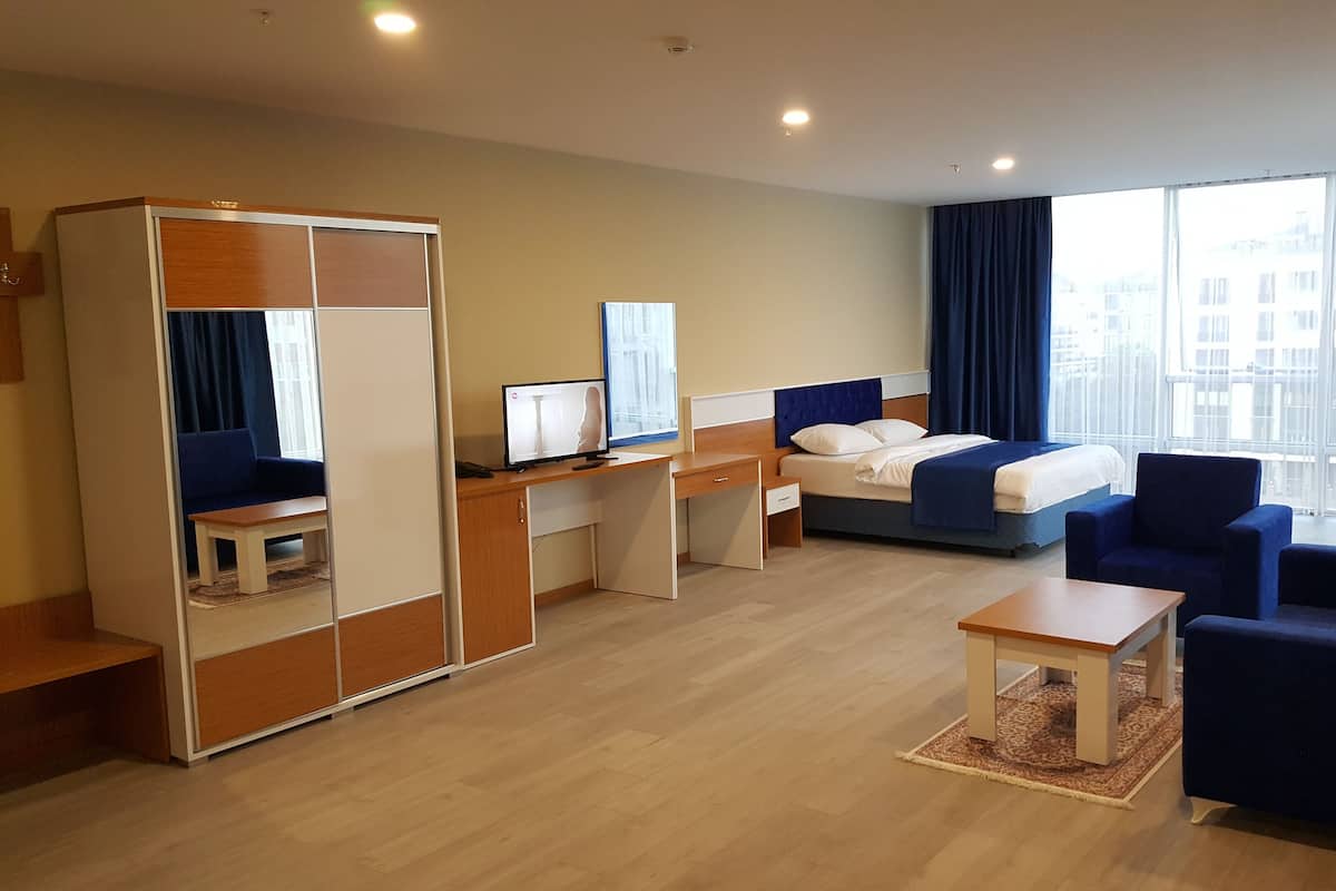 Une chambre d’hôtel moderne équipée d’un lit, d’un bureau, d’une chaise et d’une armoire.