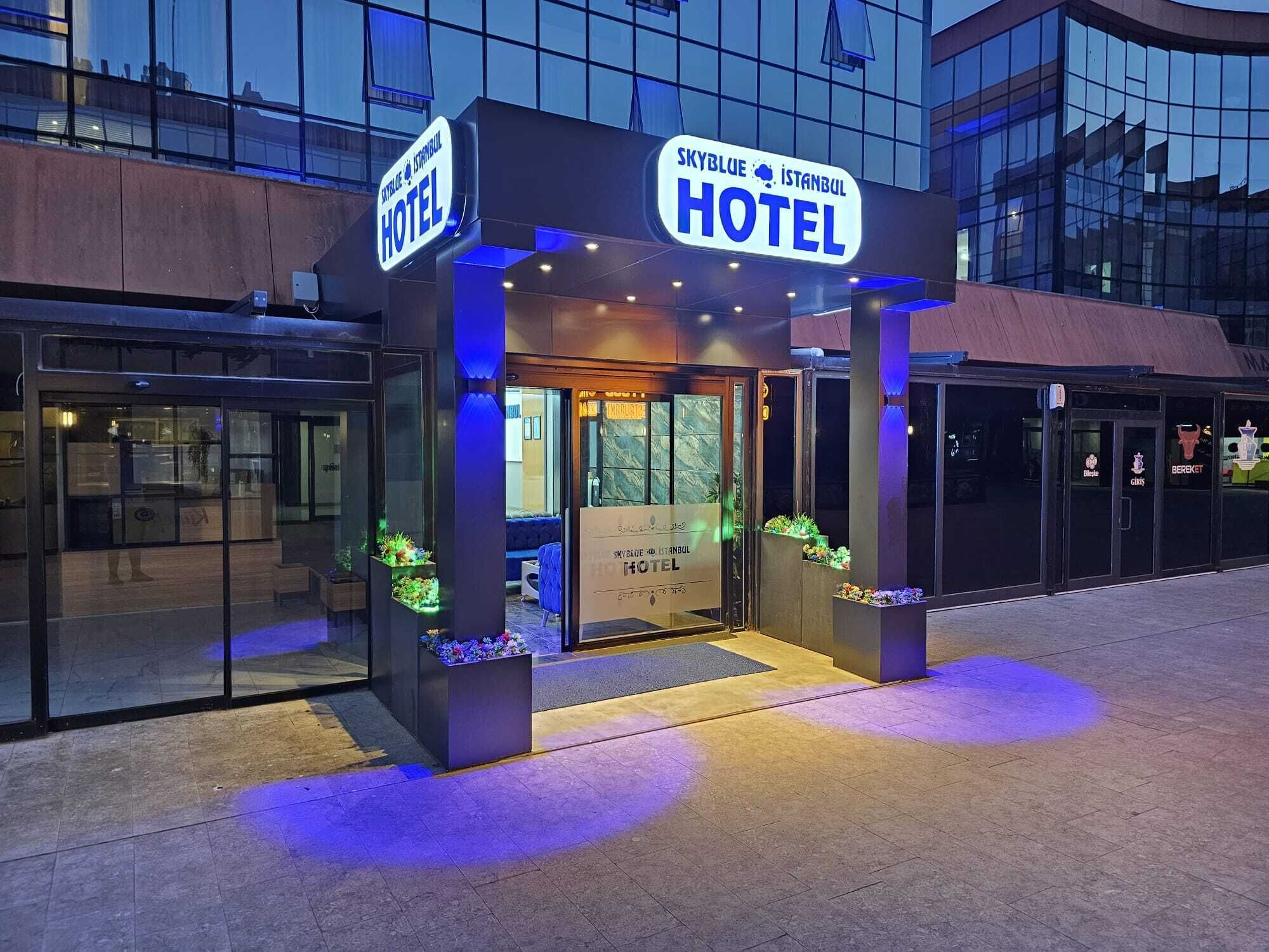 The exterior of the Skyblue Istanbul Hotel with a modern design, featuring glass doors and illuminated signage.