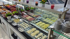 Un bufé con distintos alimentos y una vitrina.