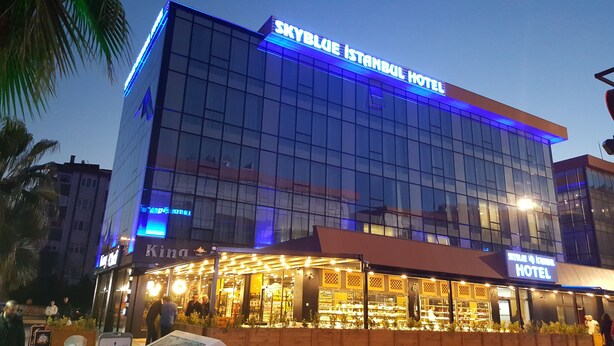 Un hotel moderno con fachada de vidrio y señalización iluminada.