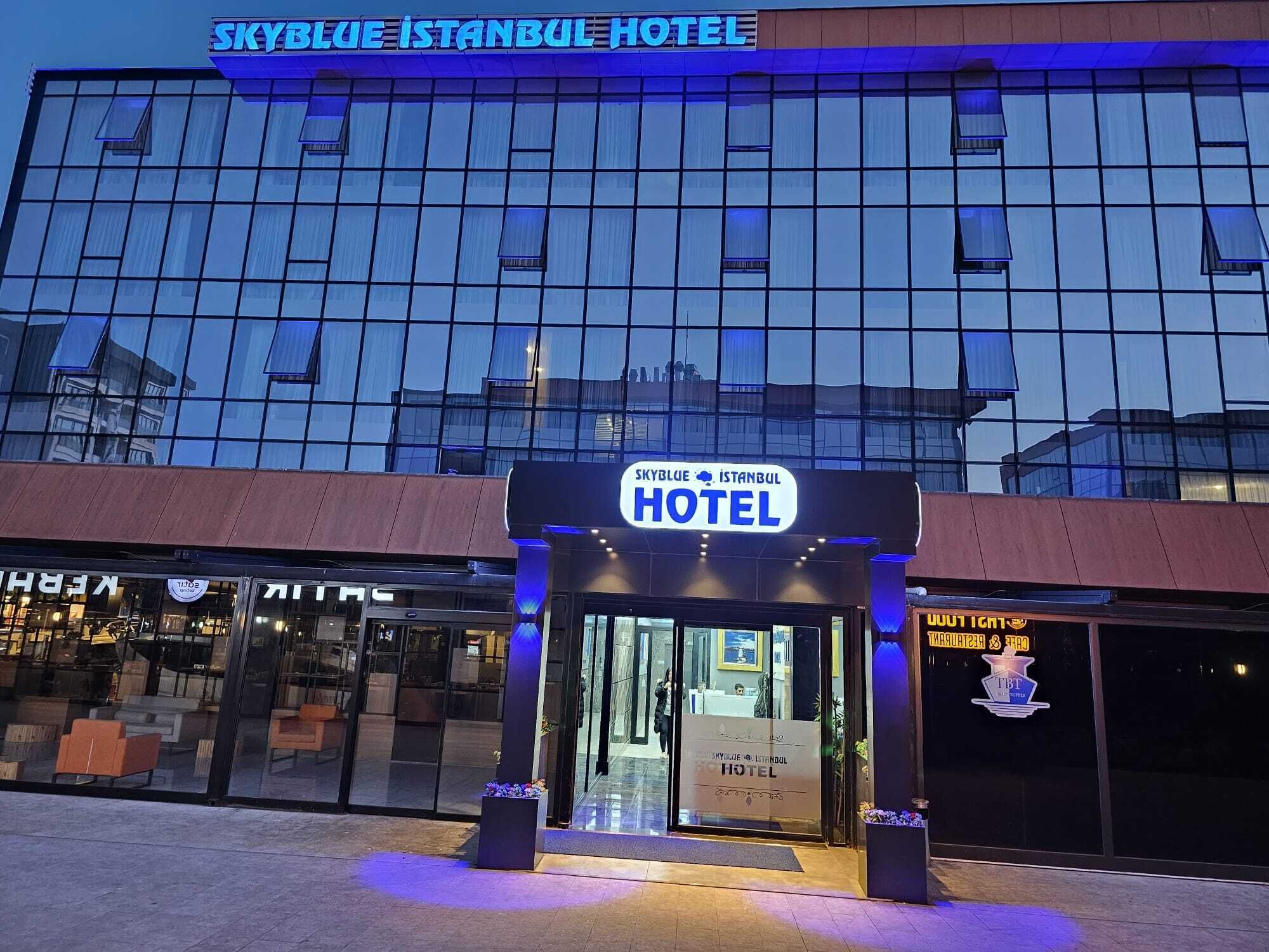 The exterior of the Skyblue Istanbul Hotel with a modern glass facade and a prominent entrance sign.