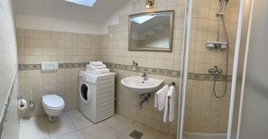 A compact bathroom with a washing machine, sink, toilet, and shower. - Apartment in Opatija with Seaview, Balcony, Air condition, WIFI (4812-2) (Opatija)