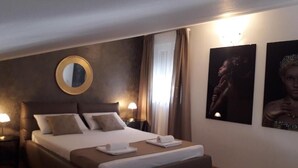 A hotel room with a large bed, two bedside tables with lamps, a round mirror on the wall, and two framed pictures. - Apartment in Opatija with Seaview, Balcony, Air condition, WIFI (4812-2) (Opatija)