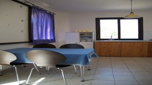 A room with a dining table, chairs, a kitchen area, and a window. - Villa near Taormina. (Furci Siculo)