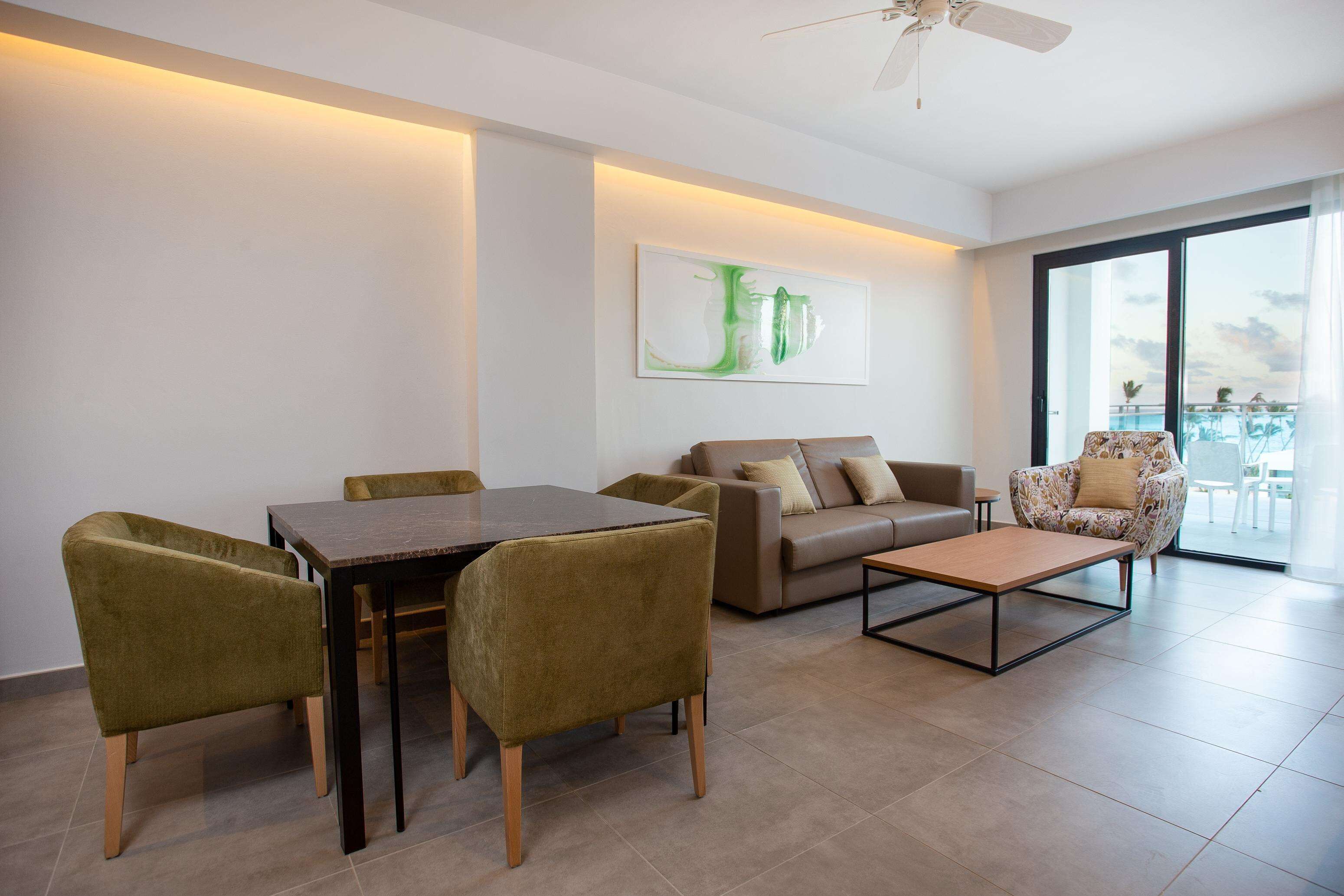 Una sala de estar moderna con una mesa de comedor, un sofá y un sillón.