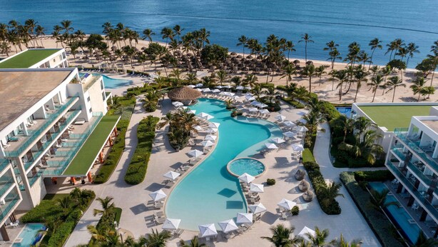 A resort with a large pool, palm trees, and a beach. - Serenade Punta Cana Beach & Spa Resort - All Inclusive (Punta Cana)