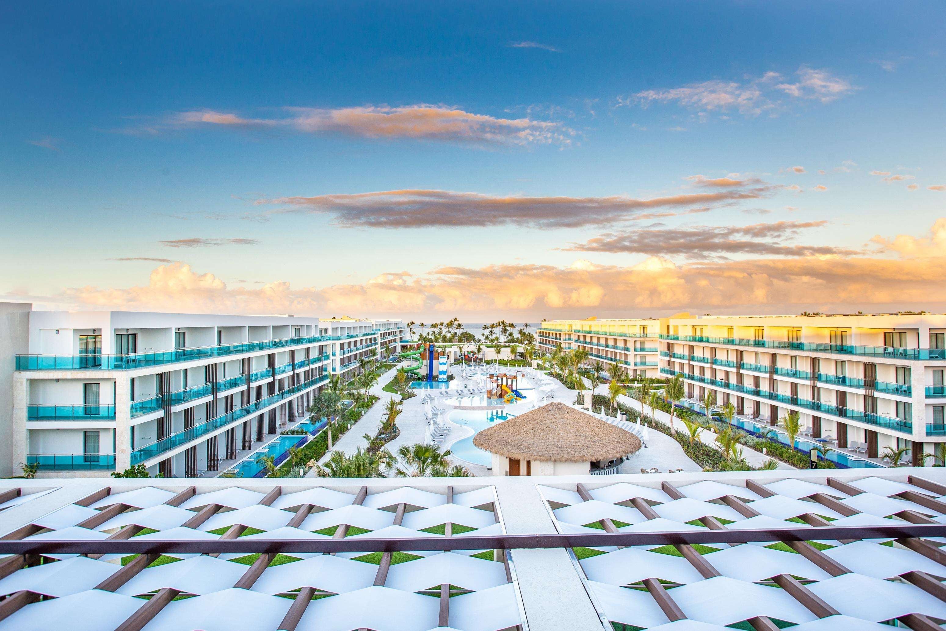 A resort with multiple balconies, a pool area, and a thatched-roof structure.