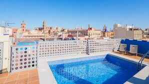 Piscina en la azotea con vistas despejadas de un paisaje urbano al fondo.