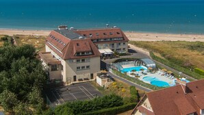 A hotel with a swimming pool, beach access, and a view of the ocean.