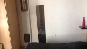 A bedroom with a bed, a wardrobe, a mirror, and a shelf with a bottle. - Studio apartment in Vrsi with Terrace, Air condition, WIFI (4824-1) (Vrsi)
