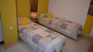 A room with two single beds, each with a patterned bedspread and a yellow pillow. A tall vase with dried plants is placed between the beds. - Apartment in Vrsi with Balcony, Air condition, WIFI (4824-3) (Vrsi)