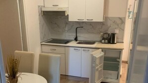 A compact kitchen with a sink, cabinets, and a coffee maker.
