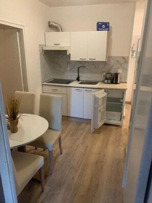 A compact kitchen with a sink, cabinets, and a coffee maker.