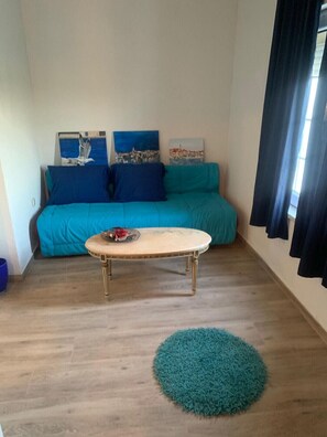 A room with a sofa, a round coffee table, and a rug.