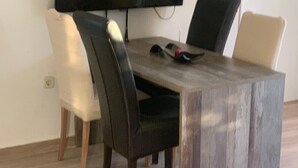 A dining area with a large table, chairs, a flat-screen TV, and a patterned rug. - Apartment in Vrsi with Balcony, Air condition, WIFI (4824-5) (Vrsi)