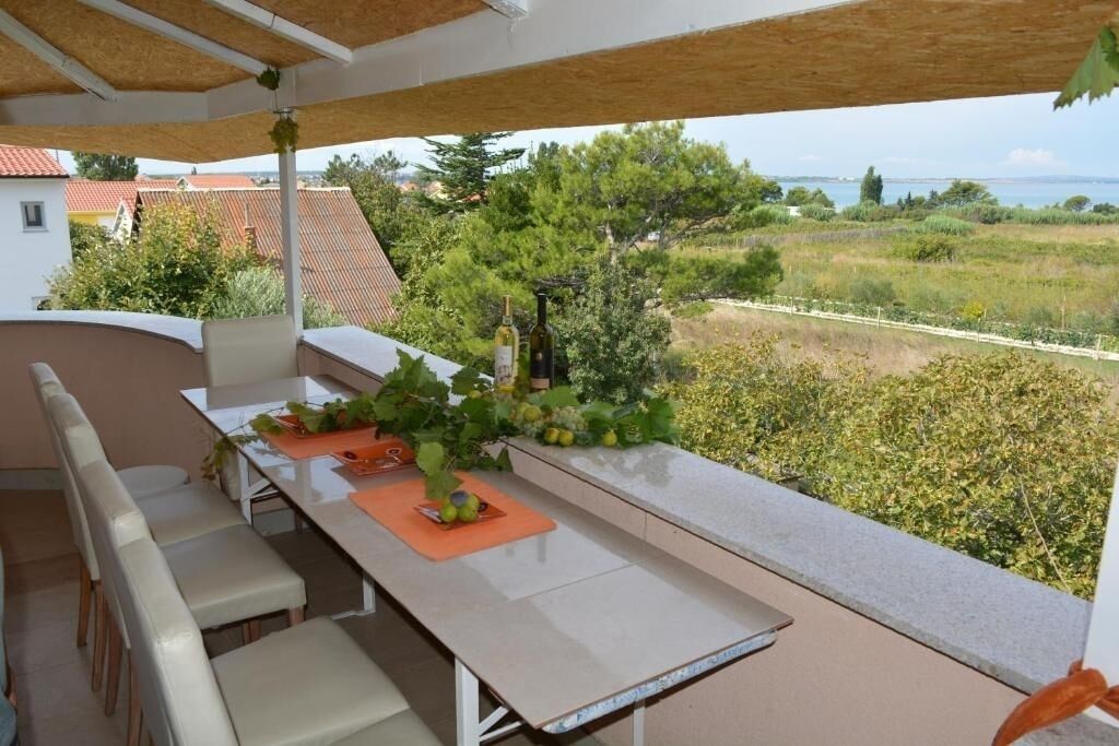 Un área de comedor al aire libre, techada, con vistas al campo.