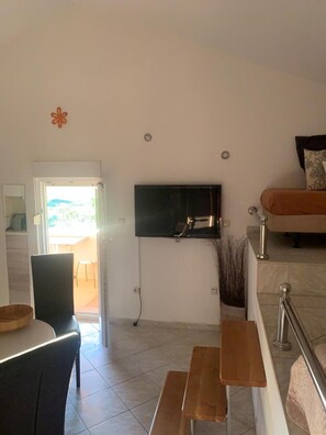 A living room with a TV, a sofa, a dining table, and a bench. - Apartment in Vrsi with Seaview, Terrace, Air condition, WIFI (4824-7) (Vrsi)