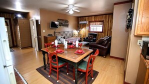 Un espacio habitable compacto con zona de comedor, sofá y ventilador de techo.