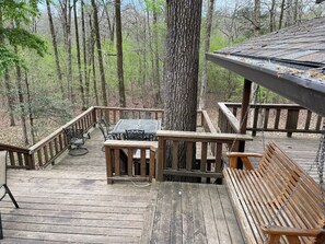 A wooden deck with a bench, a table, and a railing. - Bear Necessities - Hochatown/ Broken Bow - 3 bd (Broken Bow)