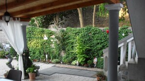 An outdoor patio area with a covered seating area, stone flooring, and potted plants. - Apartment in Zaton (Zadar) with Terrace, Air condition, WIFI, Washing machine (4828-1) (Nin)