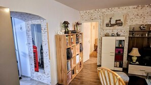 A cozy living room with a wooden bookshelf, a red telephone, and a scooter decoration on the wall. - Apartment in Zaton (Zadar) with Terrace, Air condition, WIFI, Washing machine (4828-1) (Nin)