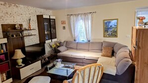 A living room with a sofa, television, and wooden furniture. - Apartment in Zaton (Zadar) with Terrace, Air condition, WIFI, Washing machine (4828-1) (Nin)