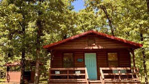 Een houten chalet met een veranda, een deur en een raam.