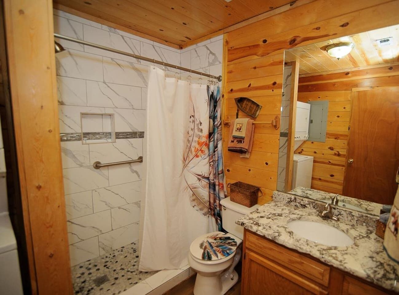Een badkamer met douche, toilet en wastafel.