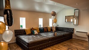 A spacious living room with a large sectional sofa, a mirror, and balloons. - Infinity Apartments Victoria Street (Liverpool)