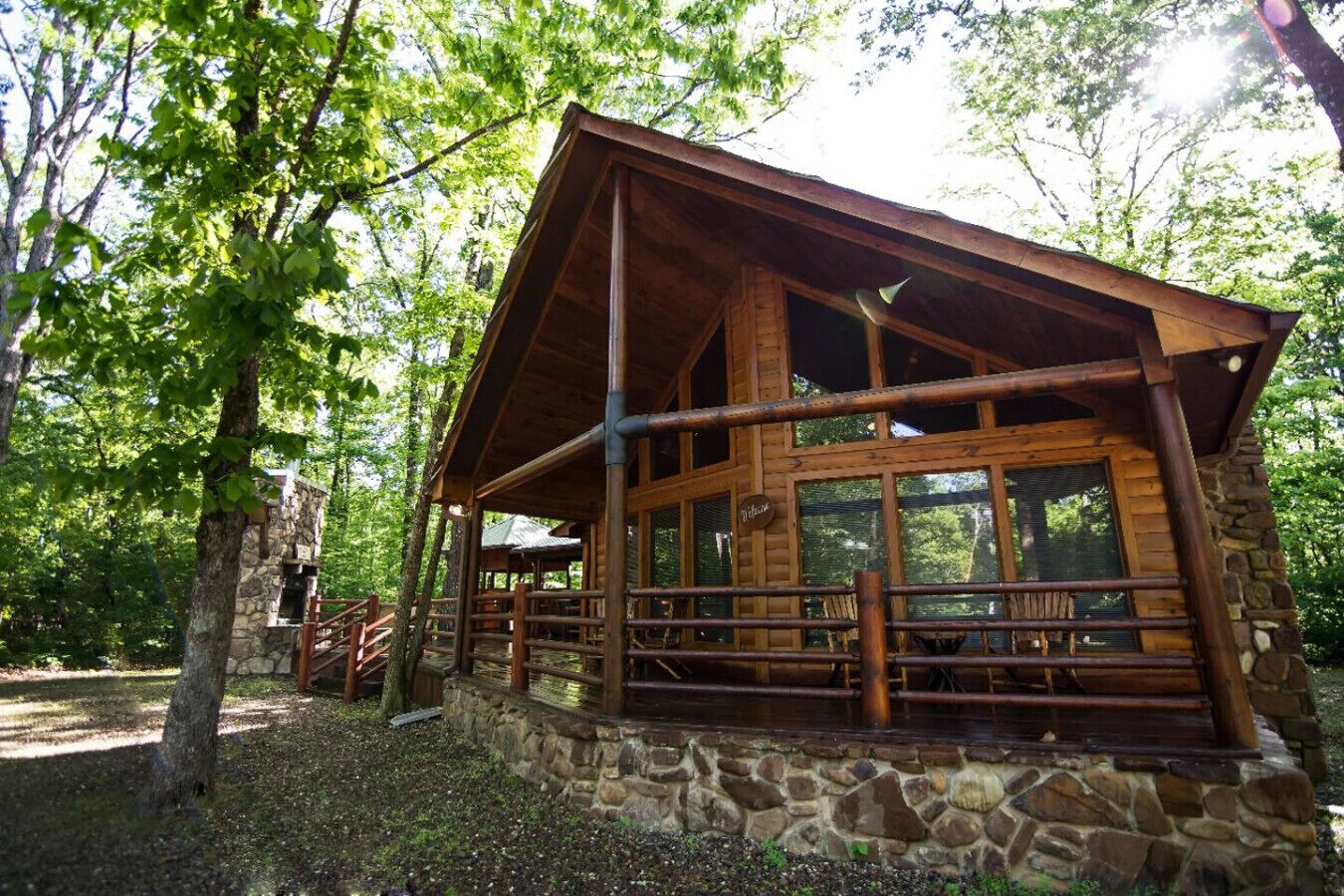 Un chalet rustique avec des fondations en pierre, des poutres en bois et de grandes fenêtres.