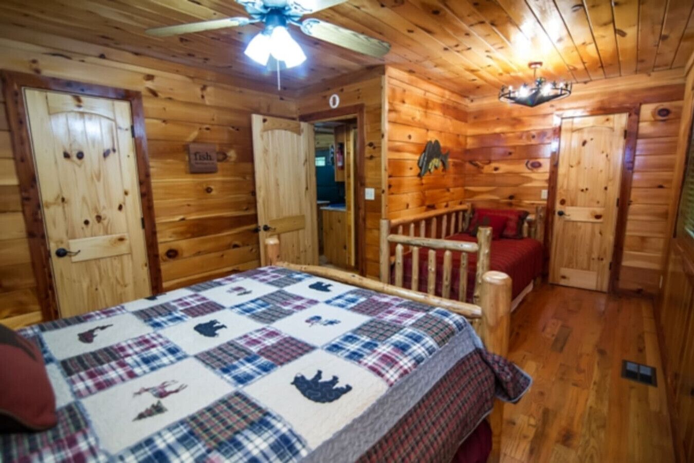 Ein Schlafzimmer in einer Holzhütte mit einem Bett, einem Deckenventilator und einem Schild, das in der Nähe ein Fischrestaurant anzeigt.