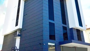 A modern building with a white facade and dark vertical accents.