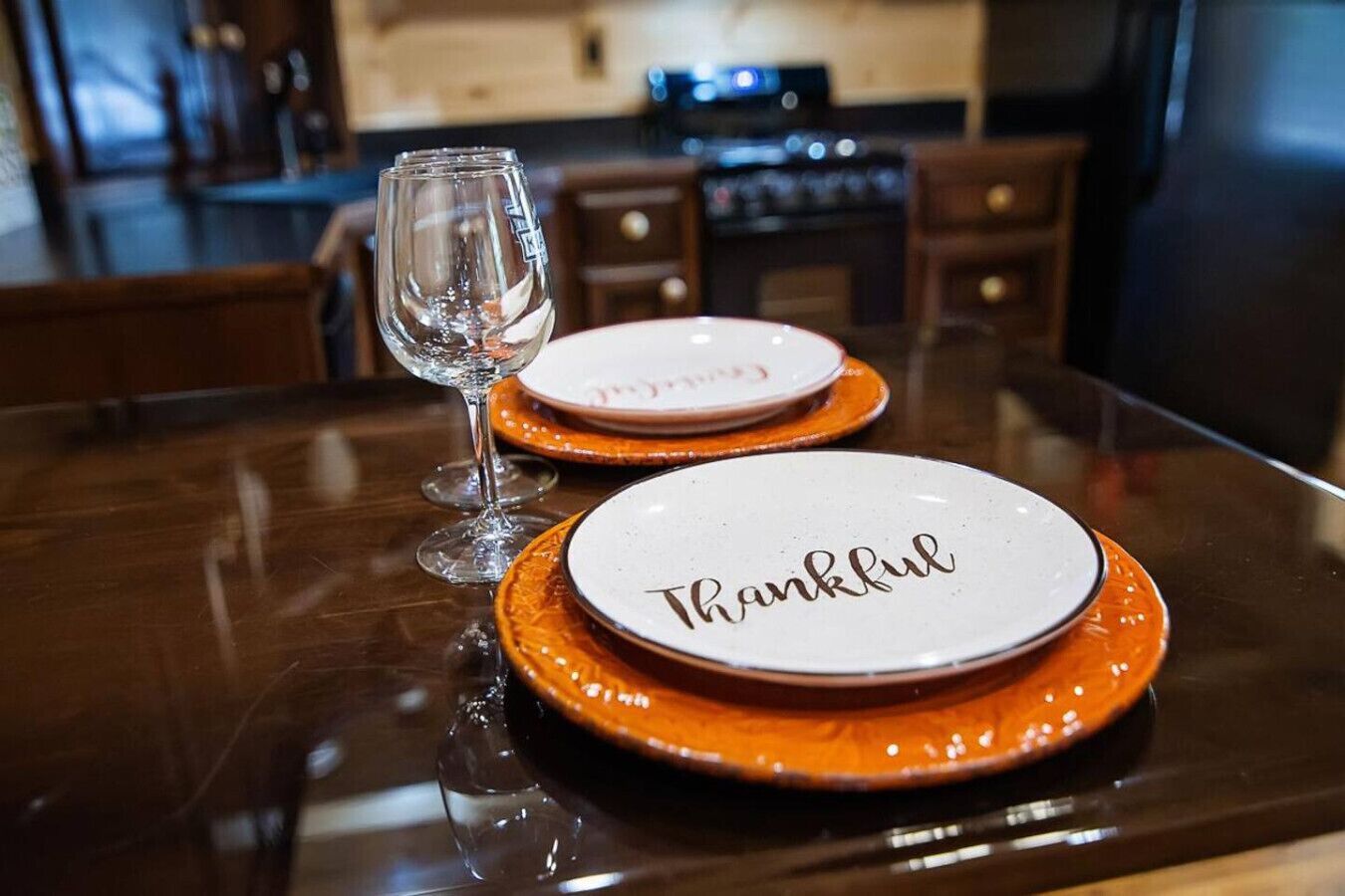 A dining table with two plates labeled "Thankful" and a wine glass.