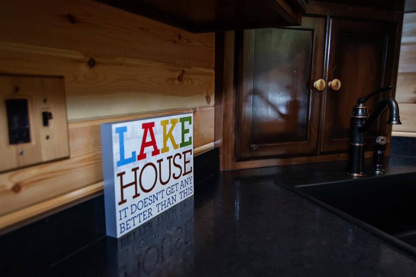 Una cocina de madera con un cartel que dice 'LAKE HOUSE IT DOESN'T GET ANY BETTER THAN THIS'.