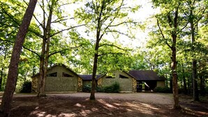 A rustic cabin with a dirt driveway, surrounded by tall trees. - Papa Bear- Broken Bow/Hochatown- 1bd (Broken Bow)