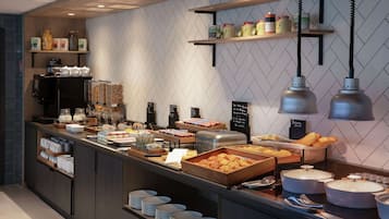 A buffet area with various food items, serving trays, and condiment containers.