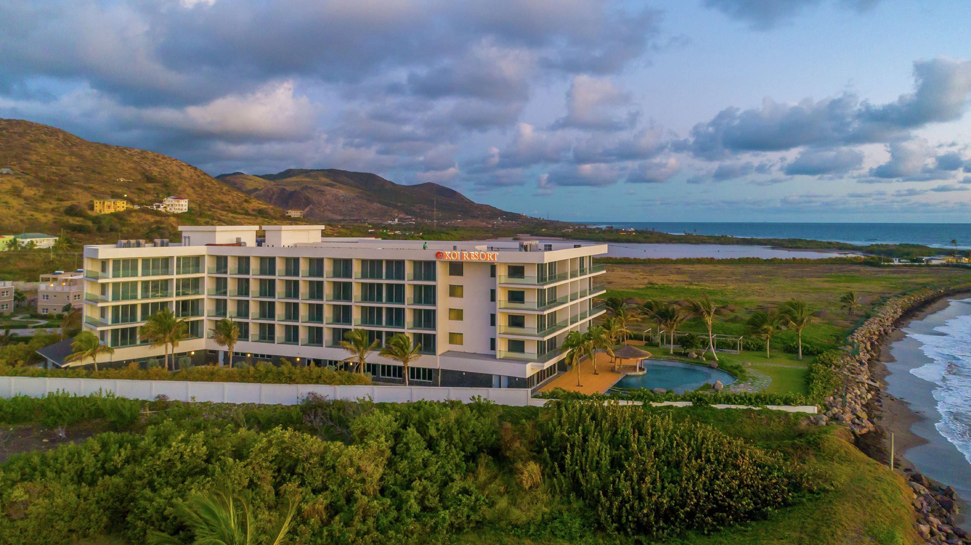 Een modern hotel met zwembad, nabij een strand en bergen.