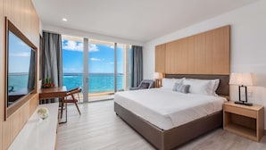 A modern hotel room with a large bed, a desk, and a view of the sea. - Koi Resort Saint Kitts, Curio Collection by Hilton (Basseterre)