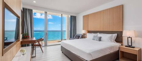 Une chambre d’hôtel moderne avec un grand lit, un bureau et une vue sur la mer.